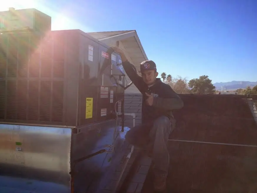 HVAC technician performing AC Tune-Up on a rooftop unit in Trumbull