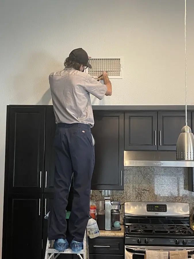 Technician inspecting an air vent during HVAC service in Trumbull
